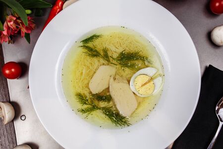 a white bowl filled with Delicious chicken noodle soup.の写真素材