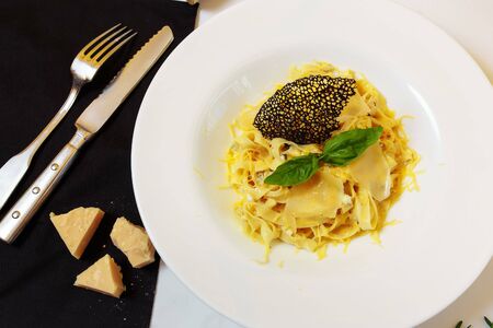 Pasta four cheeses. Homemade pasta, cream cheese sauce, Dor Blue, Cheddar, Parmesan, basil. Italian food. On a wooden background. Free space for textの写真素材