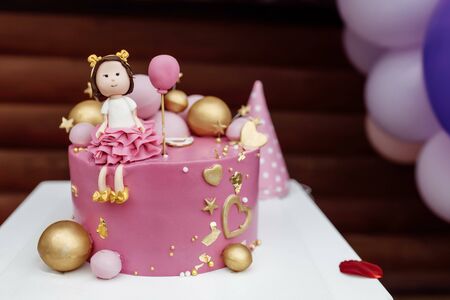 Beautiful childrens cake for a girl of 1 year old. Childrens holiday for the first birthday of the baby on the street in summer when it is warmの写真素材