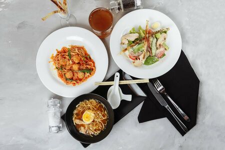 three-course set on a table in a restaurant, cafe menu. Business lunch from bowl ramen with chicken and egg, fresh caesar salad and pasta.の写真素材