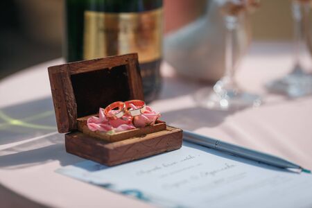 Two gold wedding rings in a beautiful wooden casket with green moss. Wedding accessories. Bride morningの写真素材