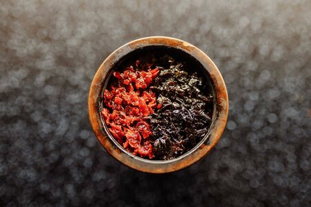 Bowl of the hookah is filled with tobacco mixed with different flavors for Smoking and leisure. Hookah tobacco smoke shisha relaxation. Close up top view imageの写真素材