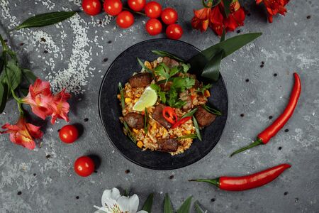 Fried rice with beef and vegetables on a gray textured background.の写真素材