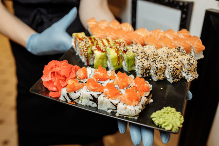 Hand Waiter holding Set Delicious fresh Sushi slate plate, Japanese raw fish in traditional...