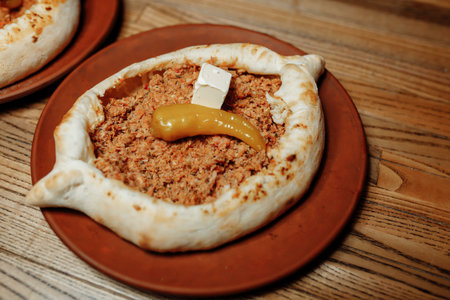 Top view on tasty traditional Adjarian Khachapuri - open baked pie with meat and pepperyolk on...