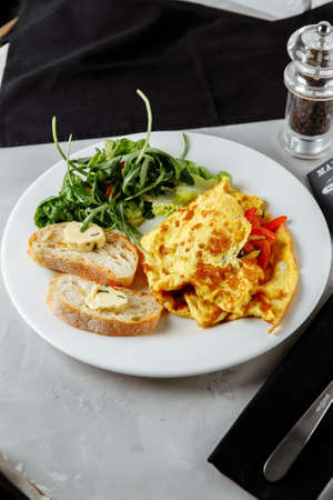 omelet with pepper and baguette, toast on a plate.の写真素材