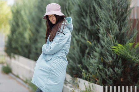 beautiful girl walks down the alley in an autumn coat.の写真素材