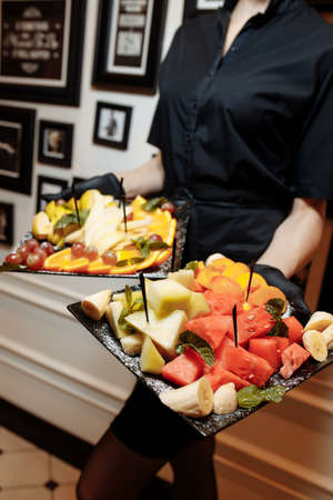 fruit platter wonderfully decorated fruits conceptual fruit platter shots in the waiter's hand luxury porcelain plate restaurant served buy.の写真素材