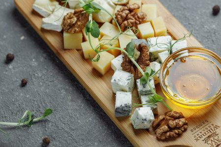 Close-up of a cheese plate. 4 types of cheese, soft white brie cheese, camembert, semi-soft briques,...