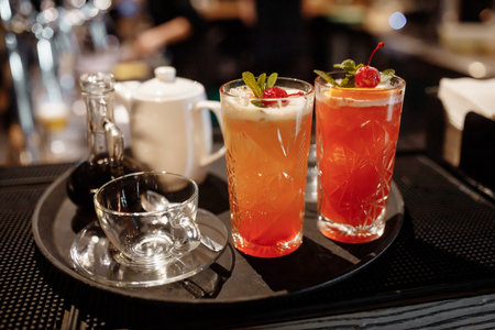 Summer cranberry lemonade garnished with mint and cherries on the bar.