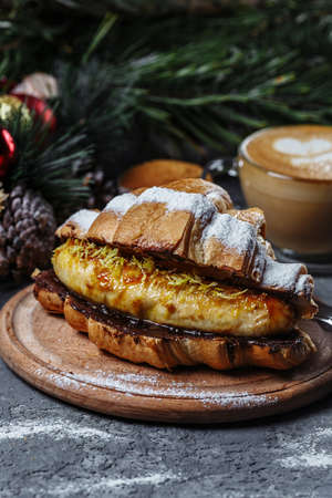 New Year's breakfast with growing. New Year's croissant with chocolate and baked banana.の写真素材
