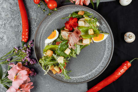 caesar salad on a gray plate with decor and copyspace.の写真素材
