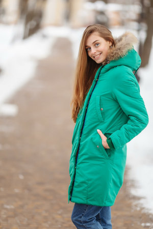 young woman are walking in the winter park. Winter park in the snow. Clothing advertising photo...