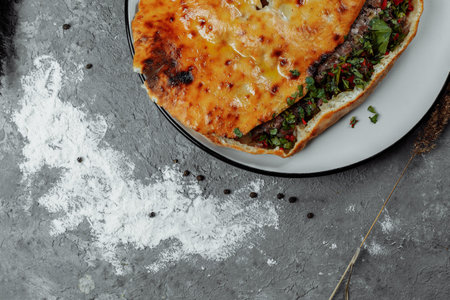 Top view on georgian khachapuri with lamb and chili peppers on the wooden table.