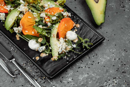 Fresh salad with fruits and greens on dark canvas background. Healthy food.の写真素材
