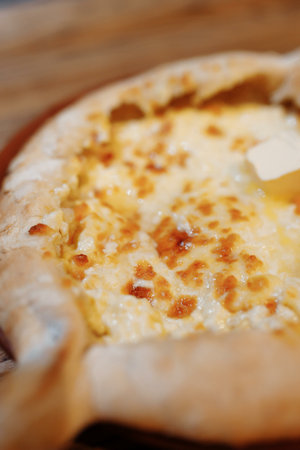 Top view on traditional Adjarian Khachapuri - open baked pie with melted salt cheese suluguni and...