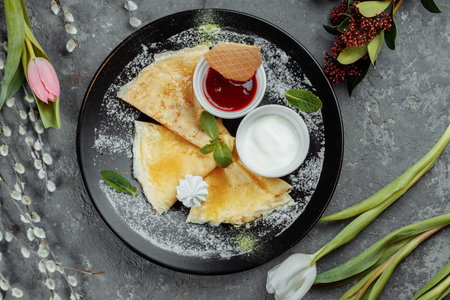 Pancakes with strawberries and creme black plate