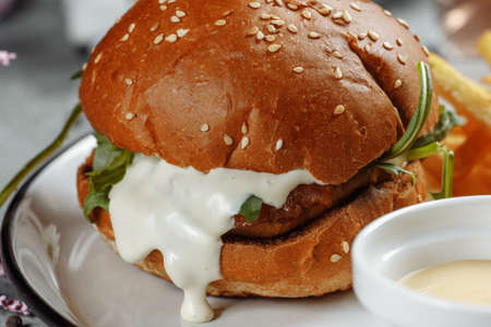 burger with fries and sauce on a white plate.の写真素材