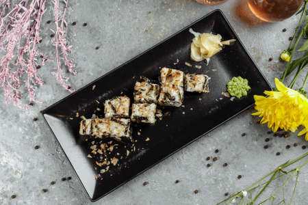 Golden dragon sushi roll with tuna, eel, cucumber, sesame seeds and tobiko caviar on wood backgroundの写真素材