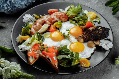 Full English breakfast with toast bread, chicken egg, mustard sauce, champignons, salad mix, cheese cream, sweet pepperの写真素材