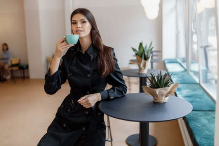 beautiful women in a coffee shop with a cup of coffee.の写真素材