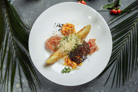 baked melon with parmesan and jamon on a white plate.の写真素材