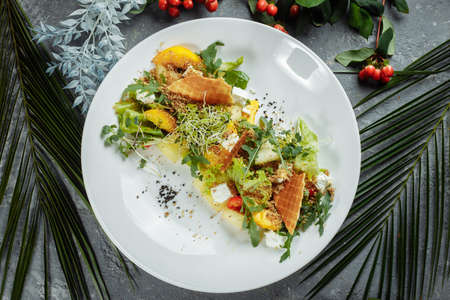 Summer diet salad with leaves of lettuce, watermelon, peach and feta cheese. On a light blue background copy space.の写真素材