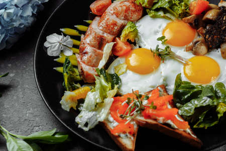Full English breakfast with toast bread, chicken egg, mustard sauce, champignons, salad mix, cheese cream, sweet pepper.の写真素材