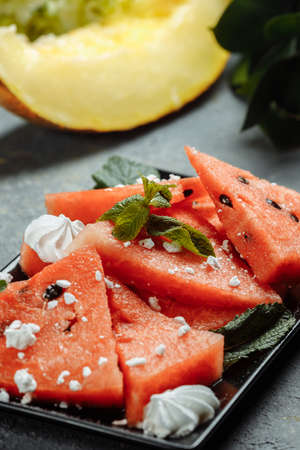 Pieces of fresh red watermelon on a black plateの写真素材