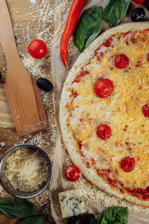 homemade italian four cheeses pizza. Pizza on rustic wooden background with tomato, cheese, basilic. Copy space. Flat lay picture for recipe or menuの写真素材