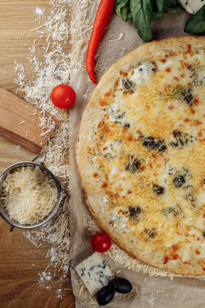 italian four cheeses pizza. Pizza on rustic wooden background with tomato, cheese, basilic. Copy space. Flat lay picture for recipe or menuの写真素材