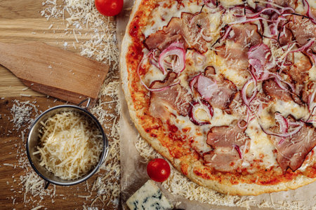 Pizza with chicken cheese and pepperoni, a piece of which is cut and laid out like a pakman, is on a wooden board and a brown background. Cheese spreads flowing streaksの写真素材