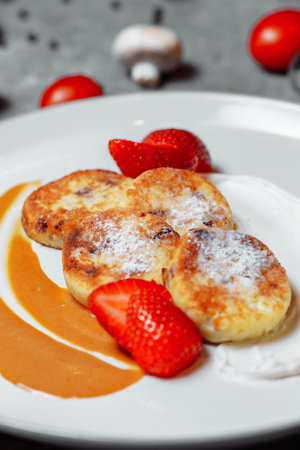 Sweet delicious food for breakfast. Pancake cheesecakes with fresh strawberry, blueberry and maple syrup. Delicious tasty pancake, morning food in cafe.の写真素材
