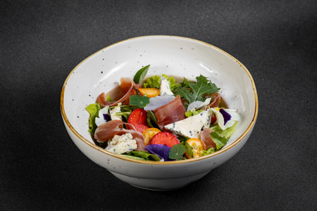 Salad mix with jamon, baby mozzarella, strawberries and vinaigrette sauce.の写真素材