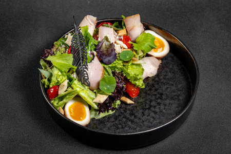 Plate of Fresh Green Salad with turkey ham, mozzarella and tomato isolated on white backgroundの写真素材