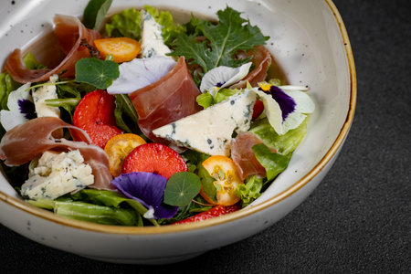 Salad mix with jamon, baby mozzarella, strawberries and vinaigrette sauce.の写真素材