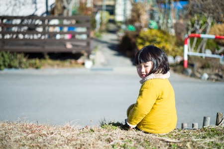 Children looking back at the bankの写真素材