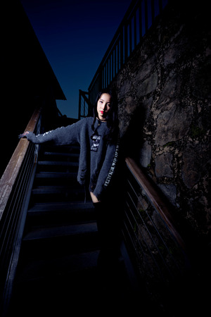 Lady in sweater standing in the darkのeditorial素材
