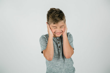 Little boy with his hands covering his ears