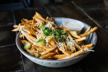 A large bowl of gourmet black truffle french fries in a bowl sprinkled with shredded parmesan...