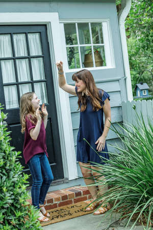 A woman holding up the house key to her daughter for their new home in this fast paced real estate marketの写真素材