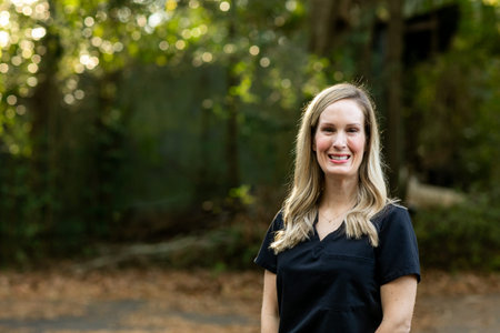 A medical professional with black scrubs outside in a natural background with copy space