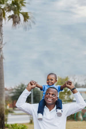 A dad holding his preschool age son on his shouldersの写真素材