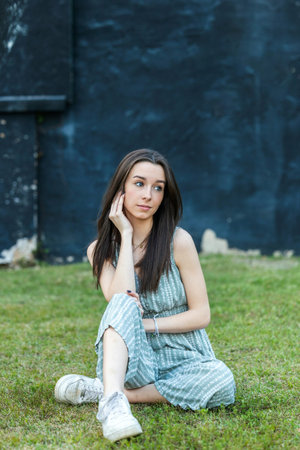A beautiful teen brunette girl with a serious look and looking away