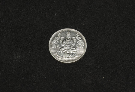 silver metal Lakshmi coin. on black background