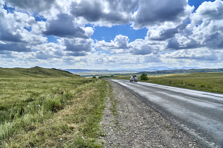 Beautiful landscape of steppe and stone mountains along the road from the city of Ust-Kamenogorsk to the Sibiny lakes (RU: Sibinskiye Ozora: Sadyrkol, Tortkara, Shalkar, Korzhynkol), East Kazakhstanの写真素材