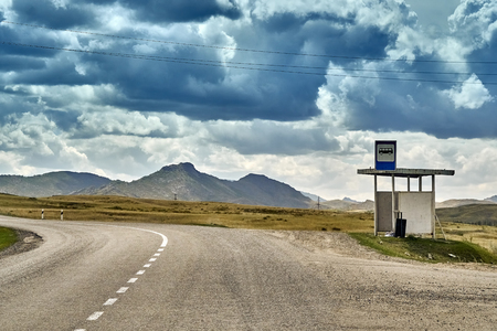 Old bus stop, beautiful landscape of steppe and stone mountains along the road from the city of Ust-Kamenogorsk to the Sibiny lakes (RU: Sibinskiye Ozora: Sadyrkol, Tortkara, Shalkar, Korzhynkol), East Kazakhstanの写真素材