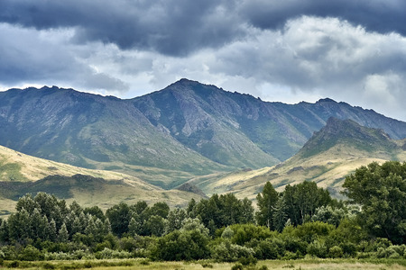 Beautiful landscape of steppe and stone mountains along the road from the city of Ust-Kamenogorsk to the Sibiny lakes (RU: Sibinskiye Ozora: Sadyrkol, Tortkara, Shalkar, Korzhynkol), East Kazakhstanの写真素材