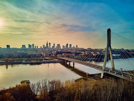Beautiful panoramic aerial drone sunset view to Warsaw city center with skyscrapers and Swietokrzyski Bridge (En: Holy Cross Bridge) - is a cable-stayed bridge over the Vistula river in Warsaw, Polandの写真素材