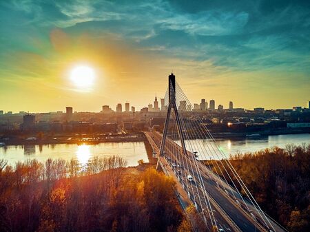 Beautiful panoramic aerial drone sunset view to Warsaw city center with skyscrapers and Swietokrzyski Bridge (En: Holy Cross Bridge) - is a cable-stayed bridge over the Vistula river in Warsaw, Polandの写真素材